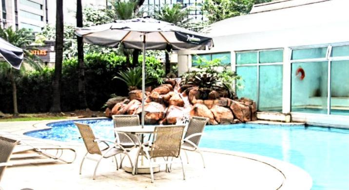 Radisson Vila Olimpia São Paulo Eksteriør billede A poolside table and chairs